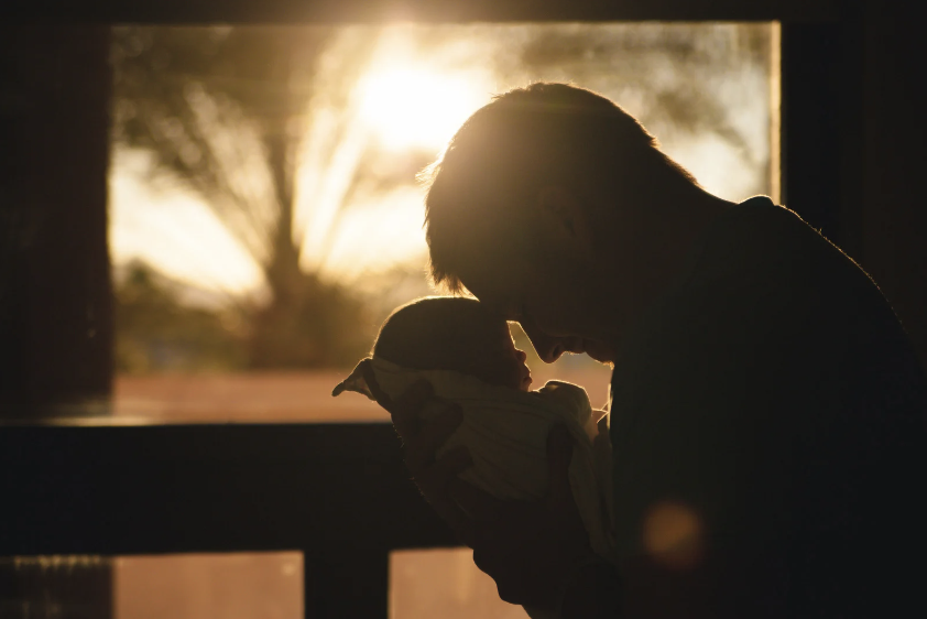 silhouette of father holding a baby